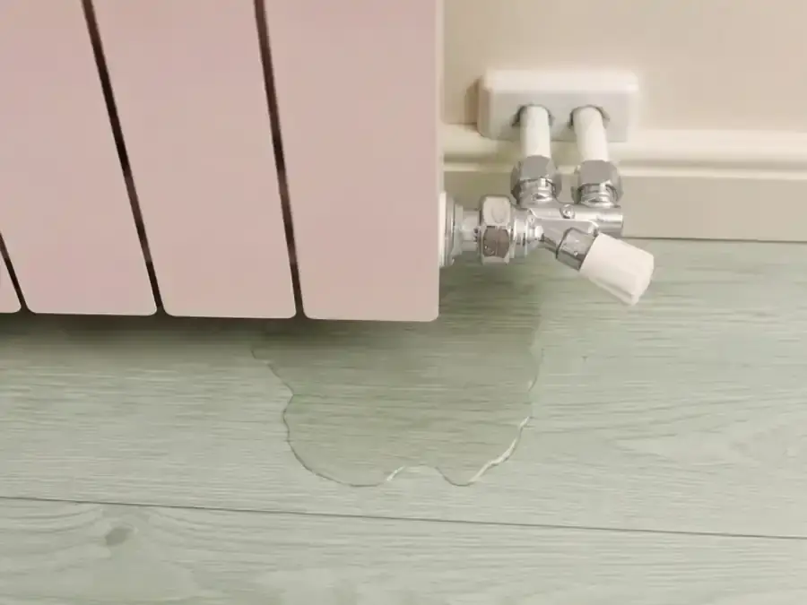 Pastel panel radiator with a visible valve leak