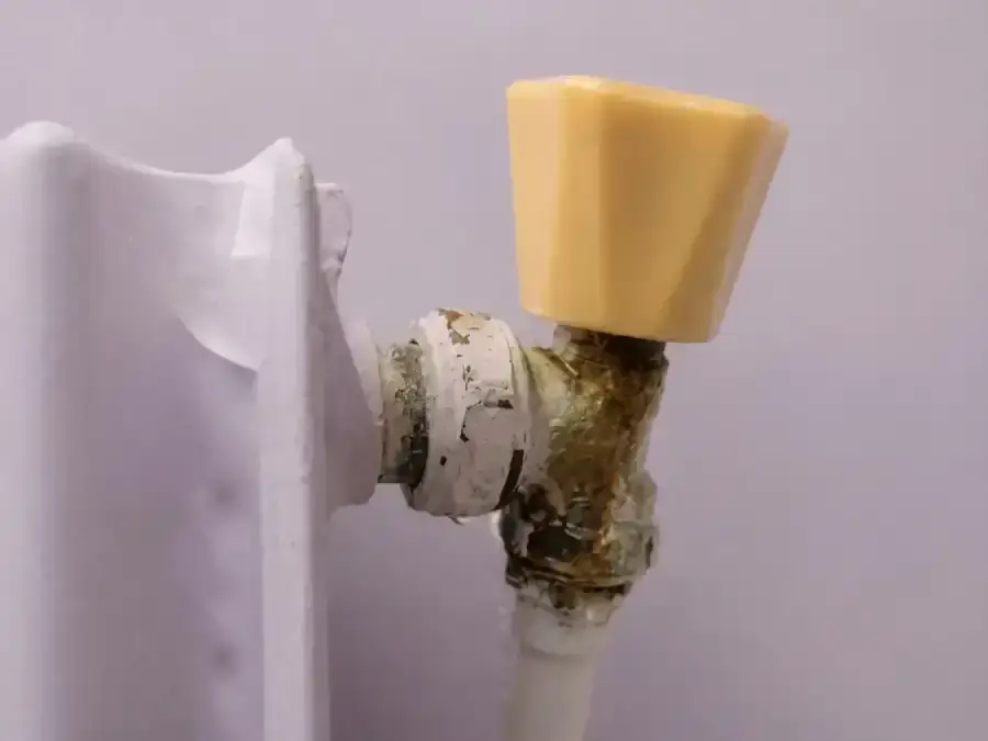 Older radiator valve showing corrosion and leakage