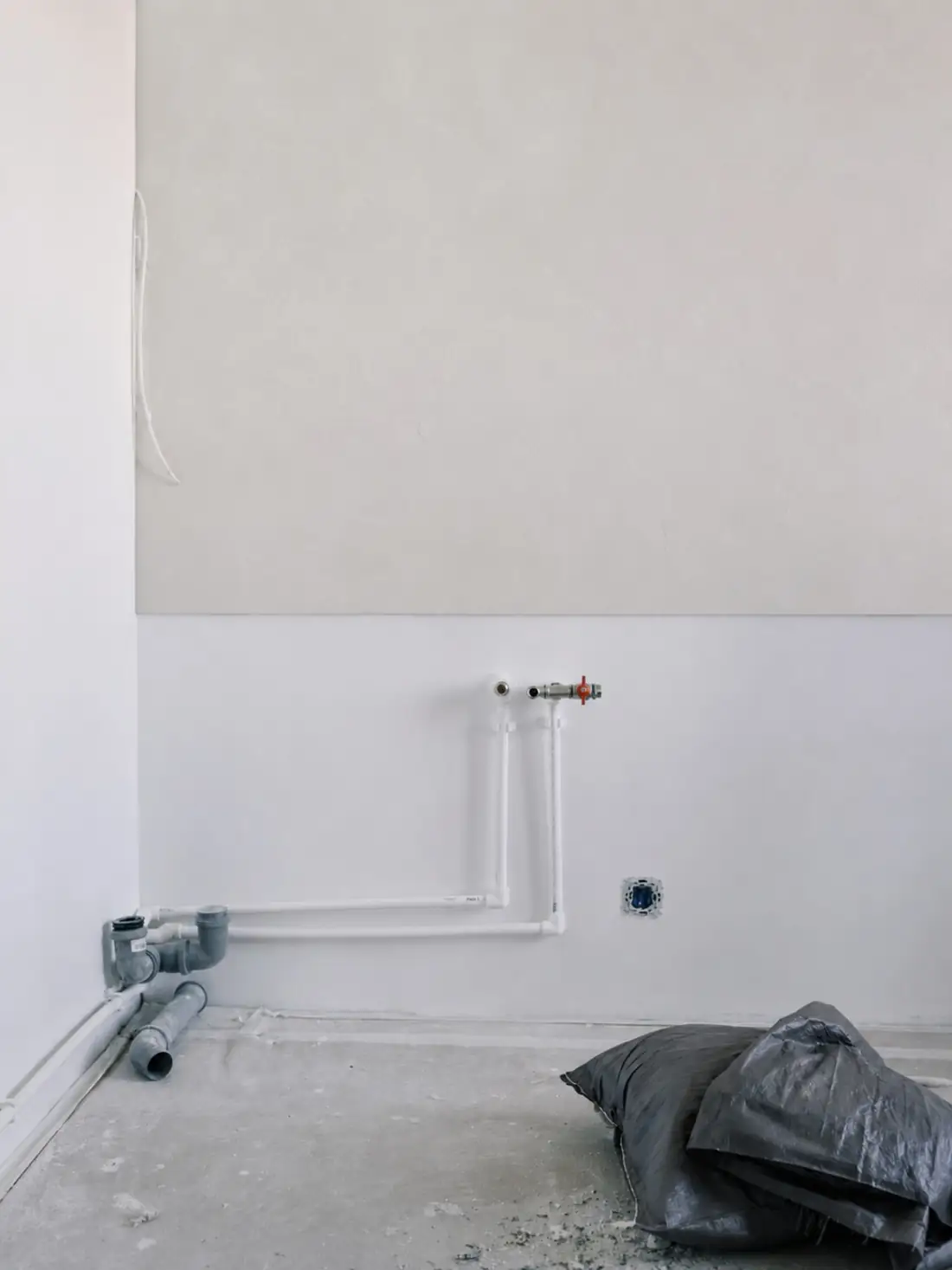 New white water and waste pipework prepared in an unfinished room